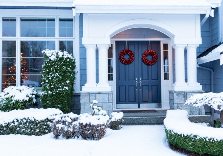 snow covered home with blue front door