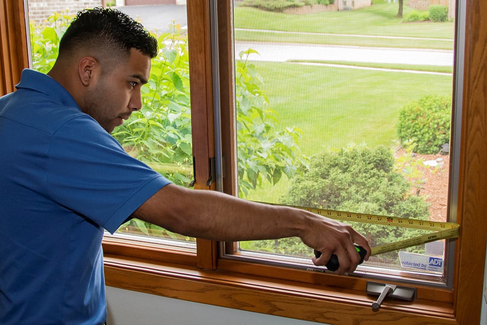 professional window installer measuring windows
